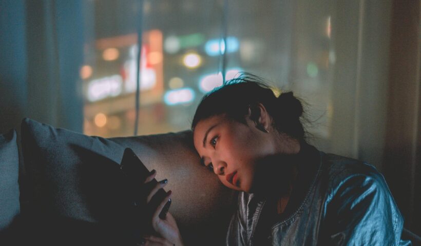 Girl looking at her phone at night